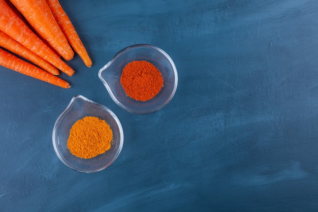 Variété D'épices Biologiques Et De Carottes Mûres Sur Une Surface Bleue.