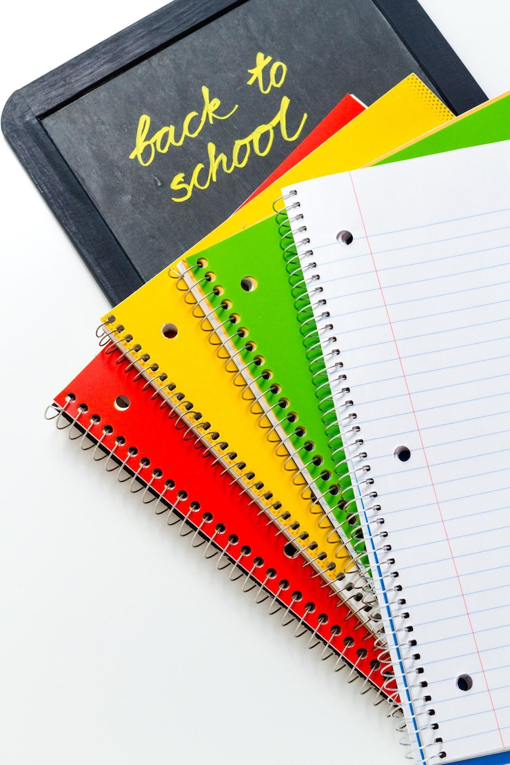 Photo variété de fournitures scolaires sur fond blanc.