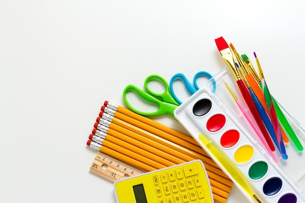 Variété de fournitures scolaires sur fond blanc.