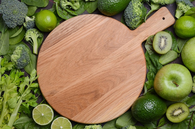 Variété De Fruits Et Légumes Verts Avec Une Planche à Découper En Bois Vide