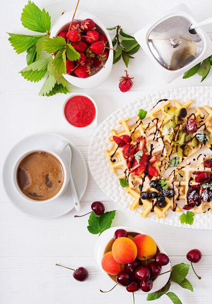 Variété de gaufrettes belges aux fruits rouges, chocolat et sirop.