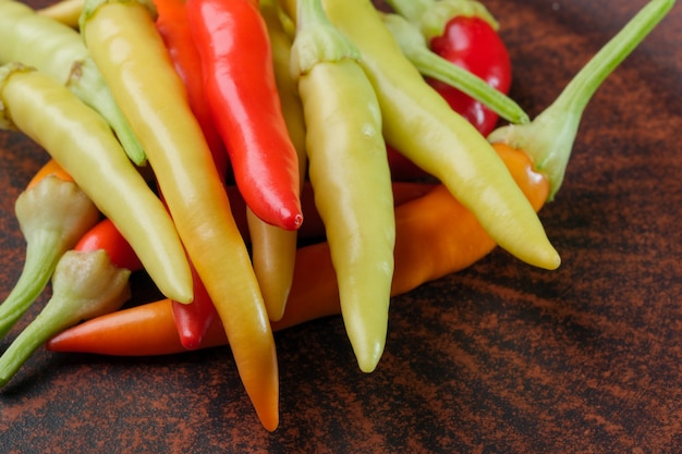 Variété d'intérieur piment amer multicolore sur une plaque d'argile brune close-up macrophotographie