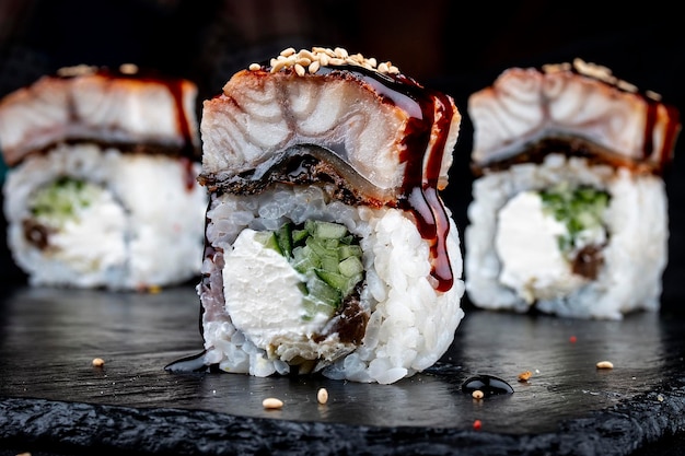 Une variété de maki sushi sur fond noir brillant