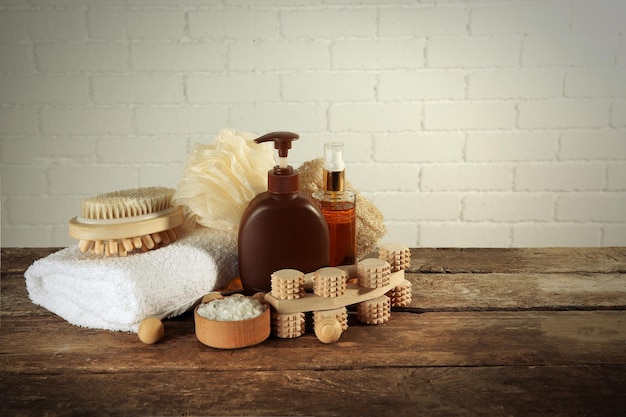 Variété d'outils de bain naturels sur table en bois sur fond de mur de briques