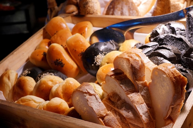 Variété de pain dans un plateau en bois avec louche pour le repas