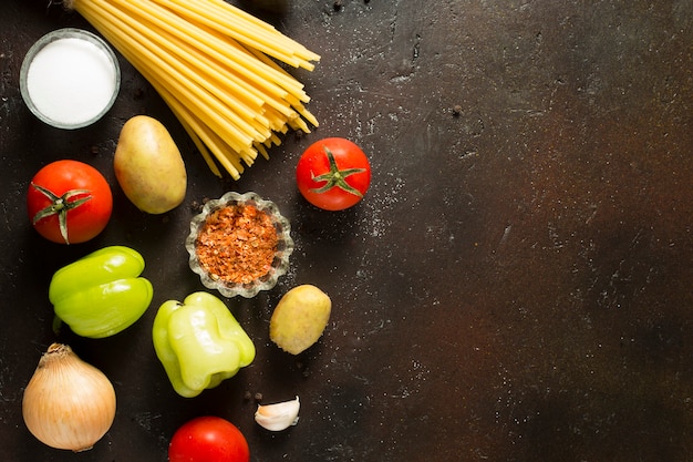 Variété de pâtes crues aux tomates fraîches et sur table marron