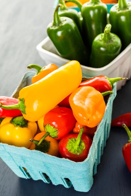 Variété de poivrons biologiques frais sur la table.