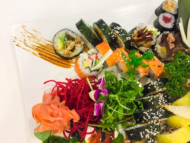 Variété de rouleaux de sushi sur une plaque blanche