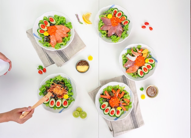 Variété de salades avec saumon, maguro, araignée, kani et fruits de mer sur la table