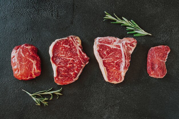 Variété de steaks de boeuf sur une surface sombre