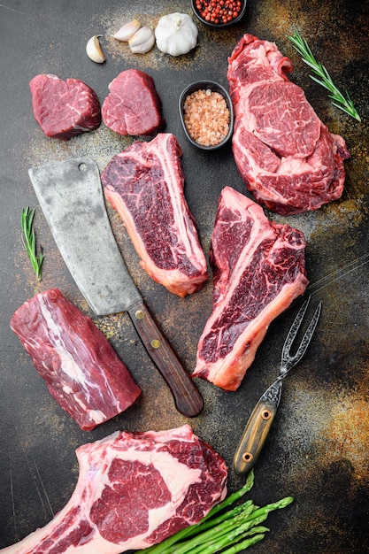 Variété de steaks de viande de bœuf crue à griller avec assaisonnement et ustensiles