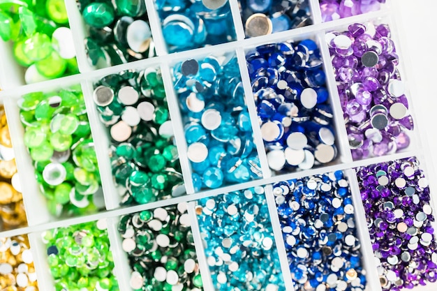 Variété de strass de couleur et de taille dans la boîte artisanale.