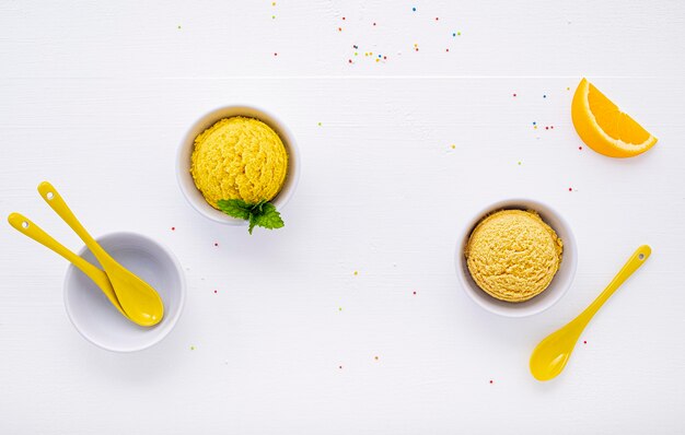 Des variétés de crème glacée au goût de citron et d'orange sur fond de bois blanc Concept de menu été et sucré