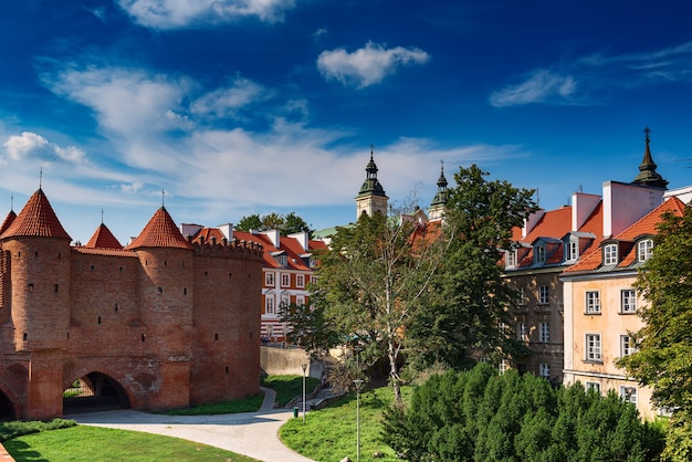 Varsovie, Pologne vue d'été sur le mur de Barbican ou Barbakan et les maisons de la vieille ville avec des arbres verts et un ciel bleu