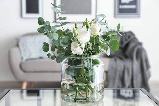 Vase avec de belles fleurs sur la table dans la chambre