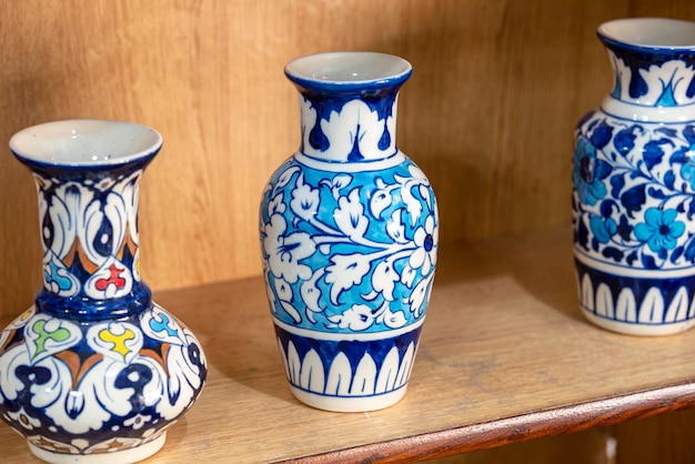 Un vase bleu et blanc avec un motif blanc est posé sur une étagère.