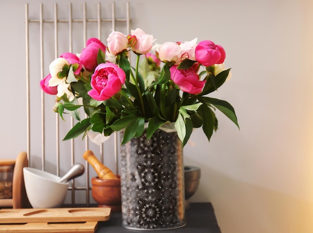 Vase avec bouquet de belles pivoines sur table dans la cuisine