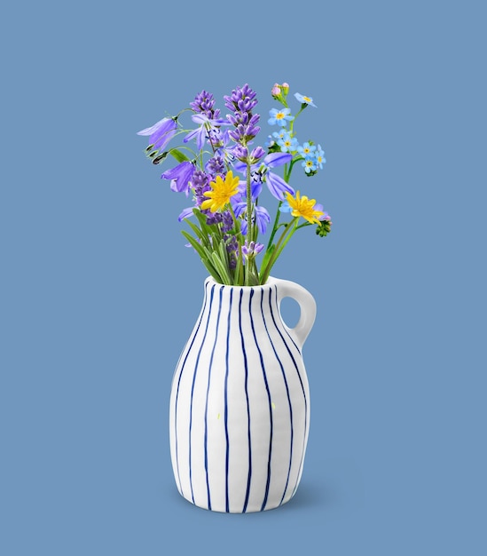Vase en céramique élégant avec bouquet de fleurs sauvages sur bleu