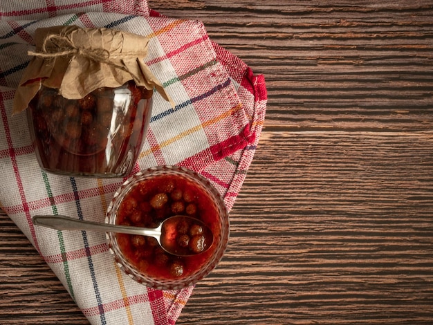 Un vase avec de la confiture de fraises un bocal fermé et une vue de dessus de baies fraîches Conservation pour l'hiver