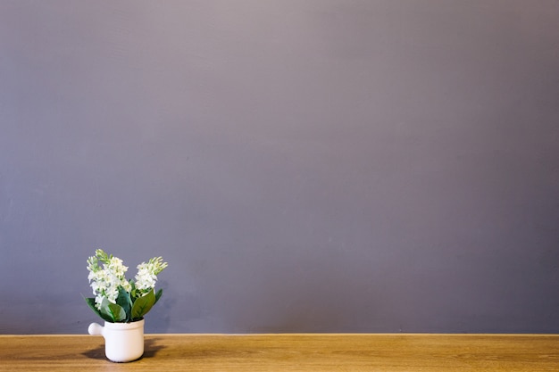 Vase à fleurs blanches Mettez-vous sur la table avec la salle intérieure au mur de briques.