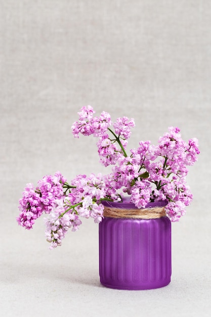 Vase avec des fleurs lilas sur fond de tissu avec espace de copie Fleurs roses Concept minimal