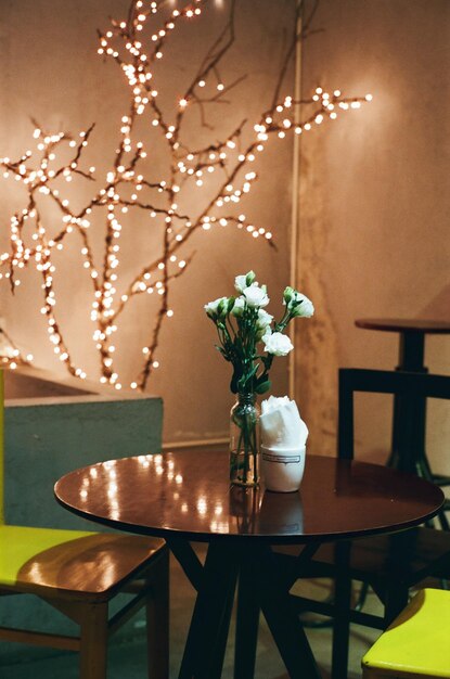 Photo vase à fleurs sur la table d'un restaurant éclairé