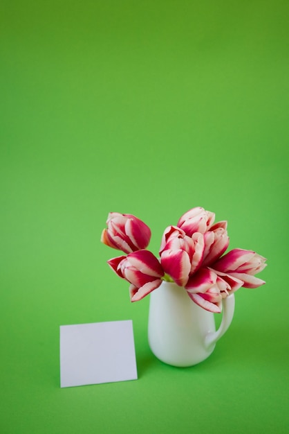 Vase avec tulipes sur fond vert avec espace de copie de carte postale