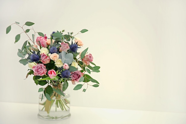 Vase en verre avec beau bouquet sur fond clair