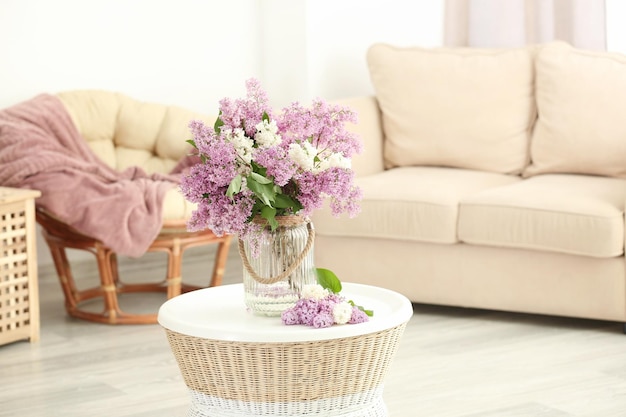 Vase en verre avec de belles fleurs lilas sur table