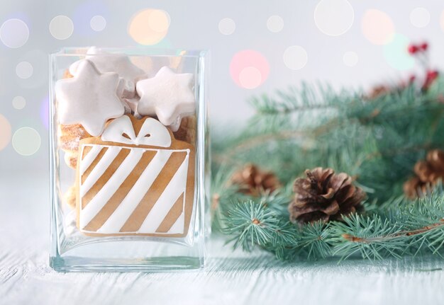 Vase En Verre Avec De Délicieux Biscuits De Noël Et Une Branche De Conifères Sur Une Table En Bois Clair