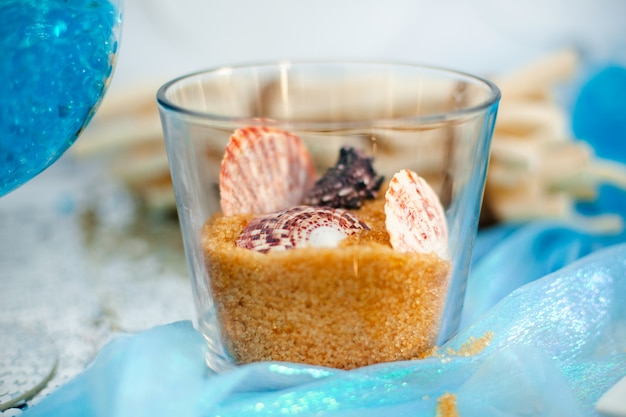 Vase en verre avec sable de cassonade sucré et différents coquillages