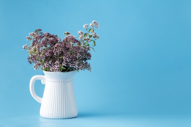 Vase vintage avec un bouquet d'origan en fleurs