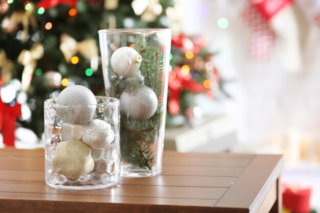 Vases en verre avec décoration de Noël sur table en bois