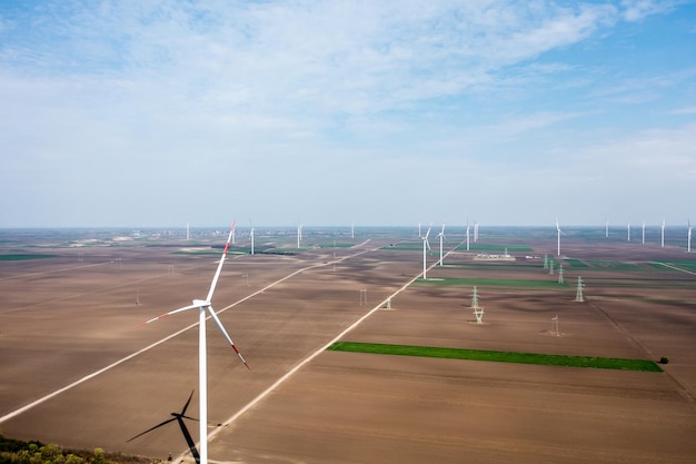 Un vaste parc éolien s'étendant sur des plaines fertiles à l'aube