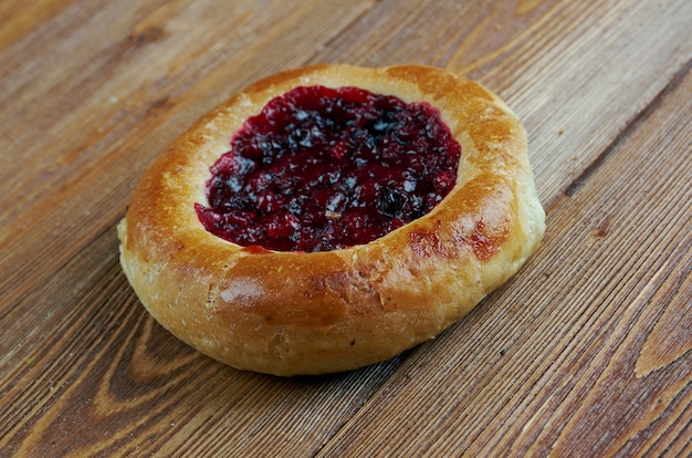 Vatrushkai- galettes avec airelle rouge.pâtisserie russe.sur un fond de bois