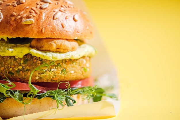 Végétalien avec un morceau sans gluten avec des graines de lin burgers de pois chiches avec roquette radis avocat concombre et houmous Concept de régime à base de plantes