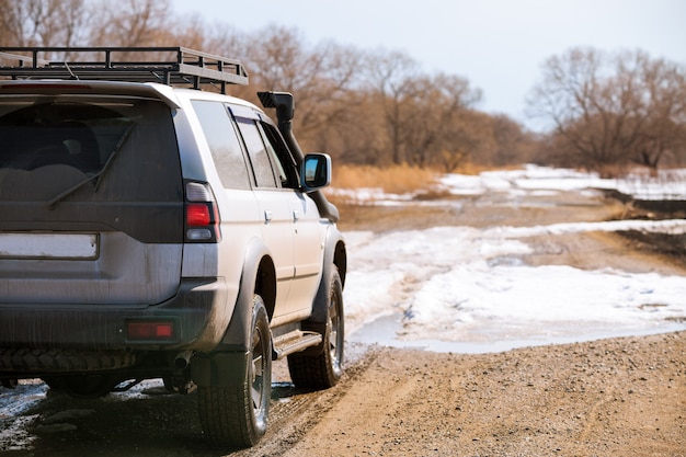 Véhicule de cross-country sur chemin de terre au début du printemps