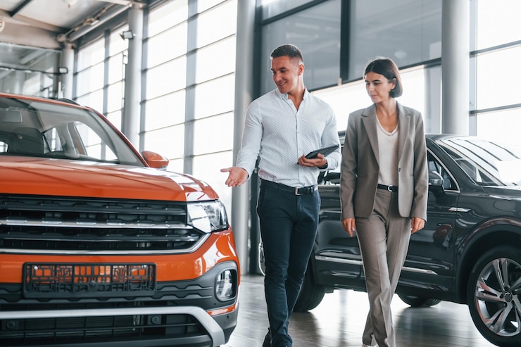 Photo véhicule moderne homme en tenue de soirée aidant le client à choisir l'automobile
