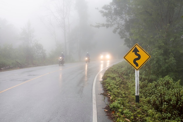 Véhicule roulant sur route courbe dans un épais brouillard