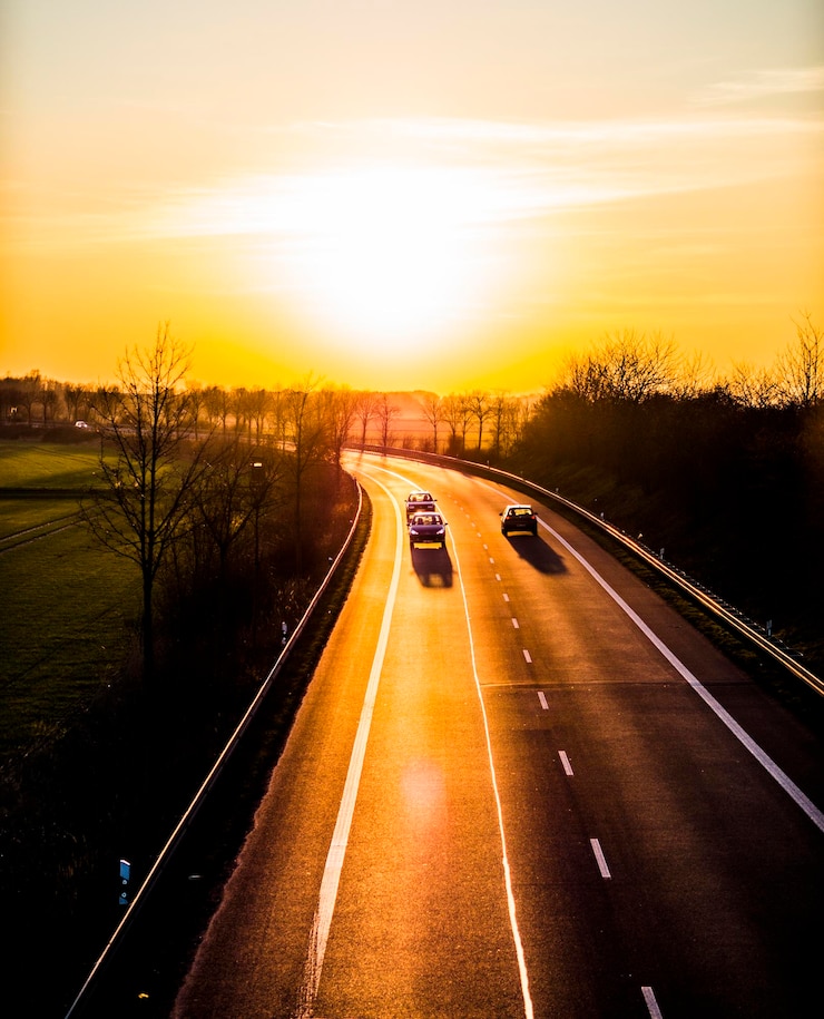 Photo véhicules sur la route contre le ciel au coucher du soleil