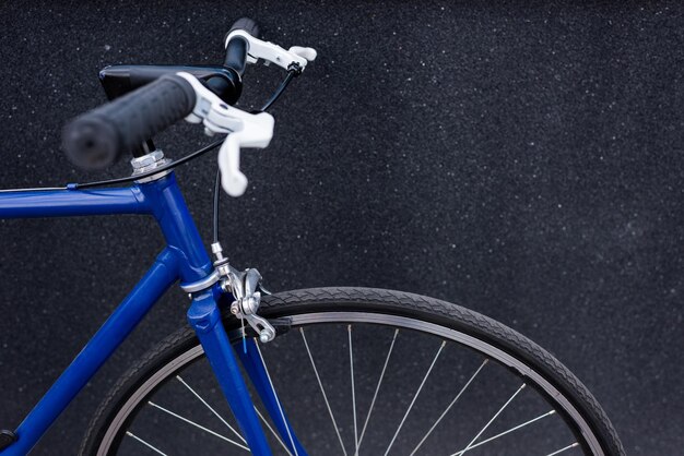 un vélo bleu mur gris