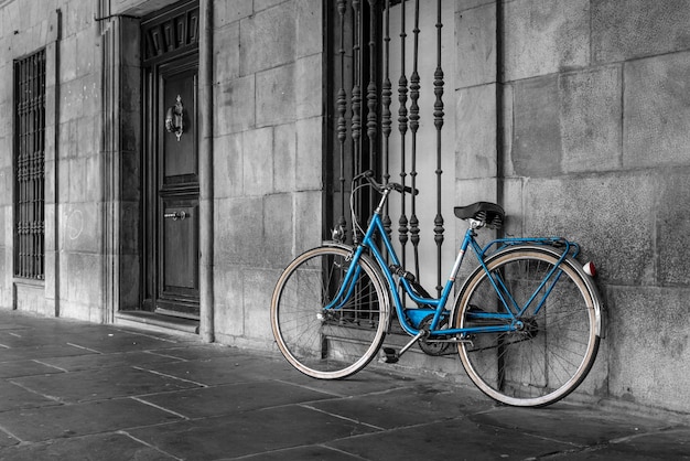 Vélo classique bleu garé sur la rue de la vieille ville