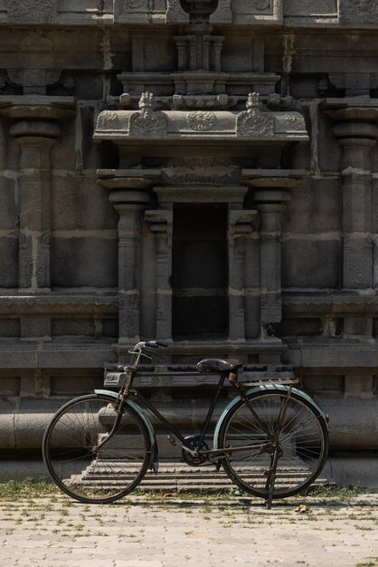 Un vélo est garé devant un bâtiment avec une statue sur le devant.