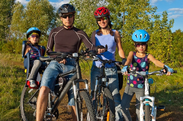 Vélo de famille en plein air. Heureux parents avec deux enfants à vélo