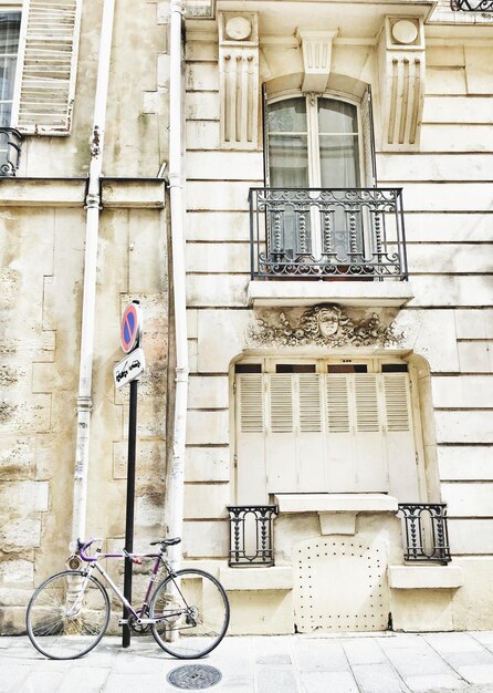 Photo vélo garée sur le trottoir contre un immeuble résidentiel