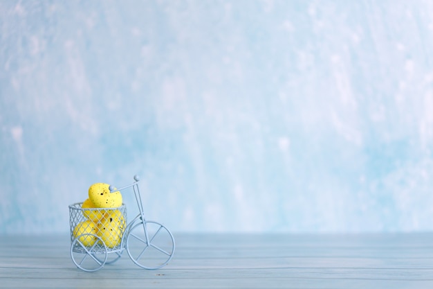 Vélo jouet blanc avec des oeufs de Pâques jaunes