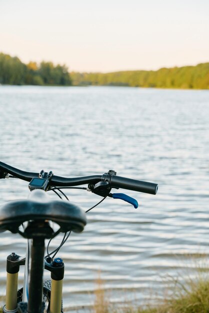 Vélo de montagne au bord d'un lac Aventures estivales au coucher du soleil à la campagne Utilisation d'un vélo en zone rurale