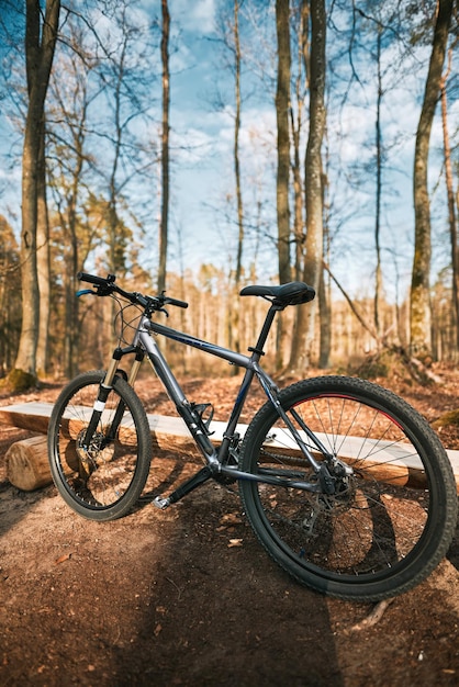 Vélo de montagne dans les bois Un vélo avec géométrie sportive et fourche à air se dresse dans la forêt Concept de passer du temps à faire des sports extrêmes à l'extérieur