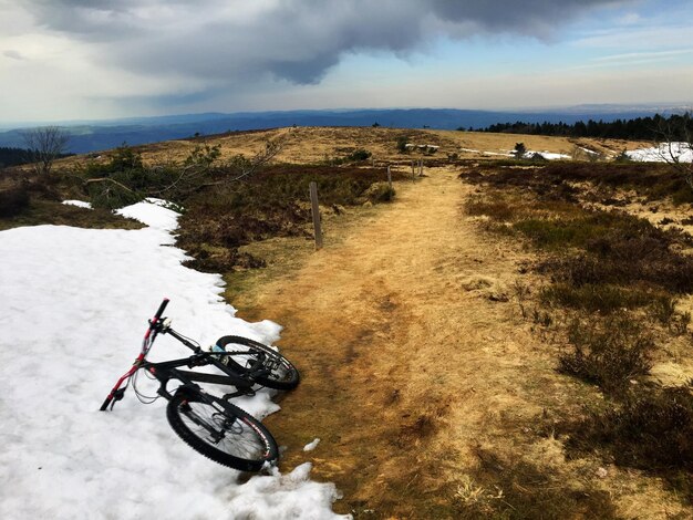 Photo vélo sur la neige contre un ciel nuageux