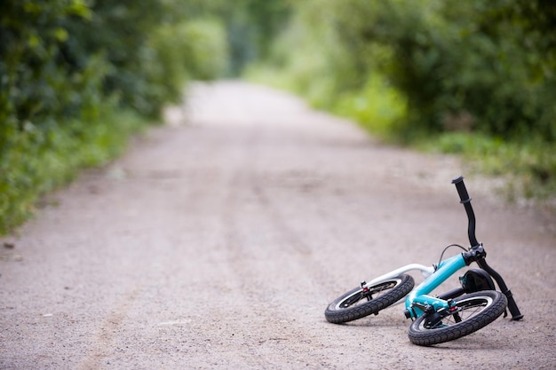 Vélo pour enfants allongé sur la route dans le parc Vélo d'équilibre pour tout-petit